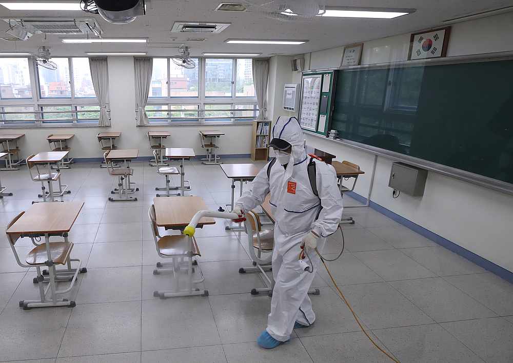 A quarantine worker sprays disinfectant at a high school, following the Covid-19 outbreak, in Seoul, South Korea May 11, 2020. u00e2u20acu201d Reuters pic