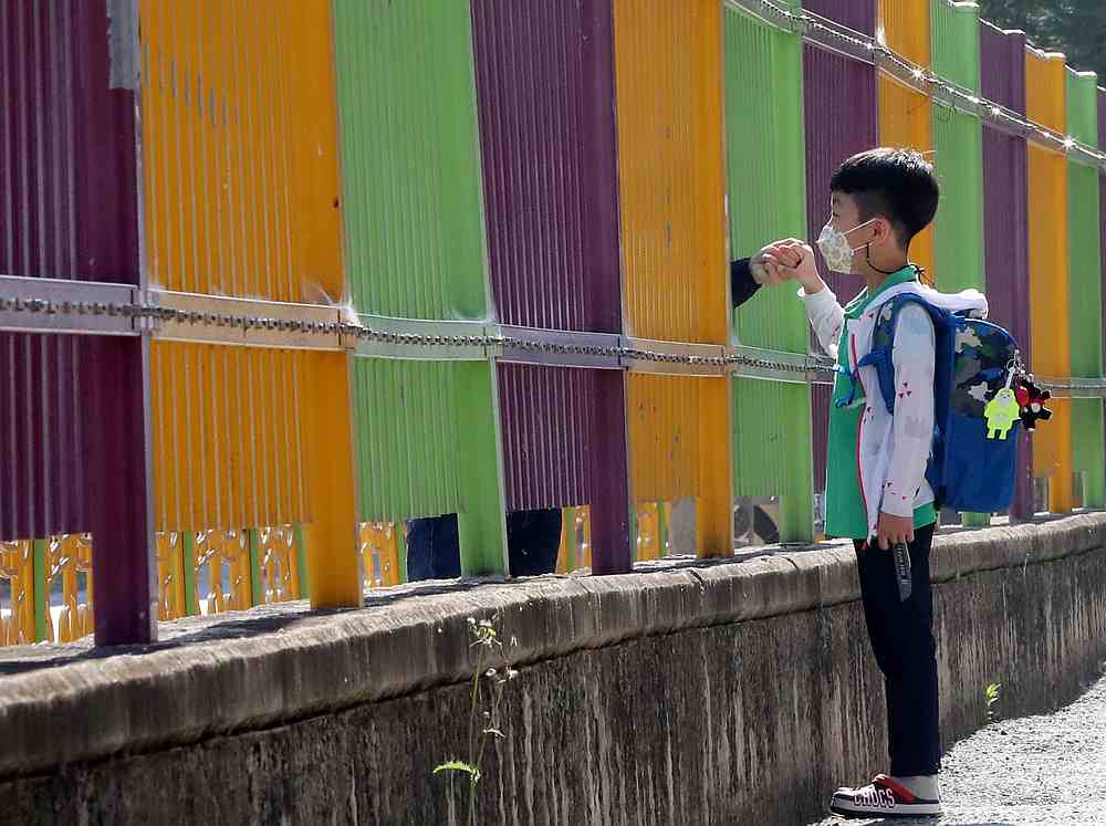 A boy holds his mother's hands as he arrives at an elementary school amid the Covid-19 outbreak in Gwangju, South Korea May 29, 2020. u00e2u20acu201d Yonhap pic via Reuters 