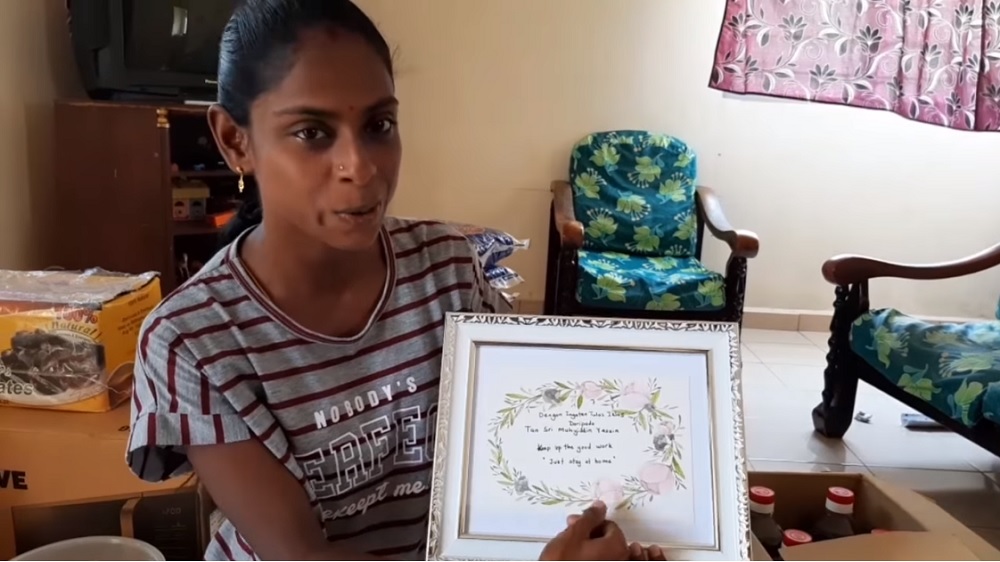 Sugu Pavithra poses with a greeting card sent by Prime Minister Tan Sri Muhyiddin Yassin. u00e2u20acu201d Picture via Youtube/Sugu Pavithra