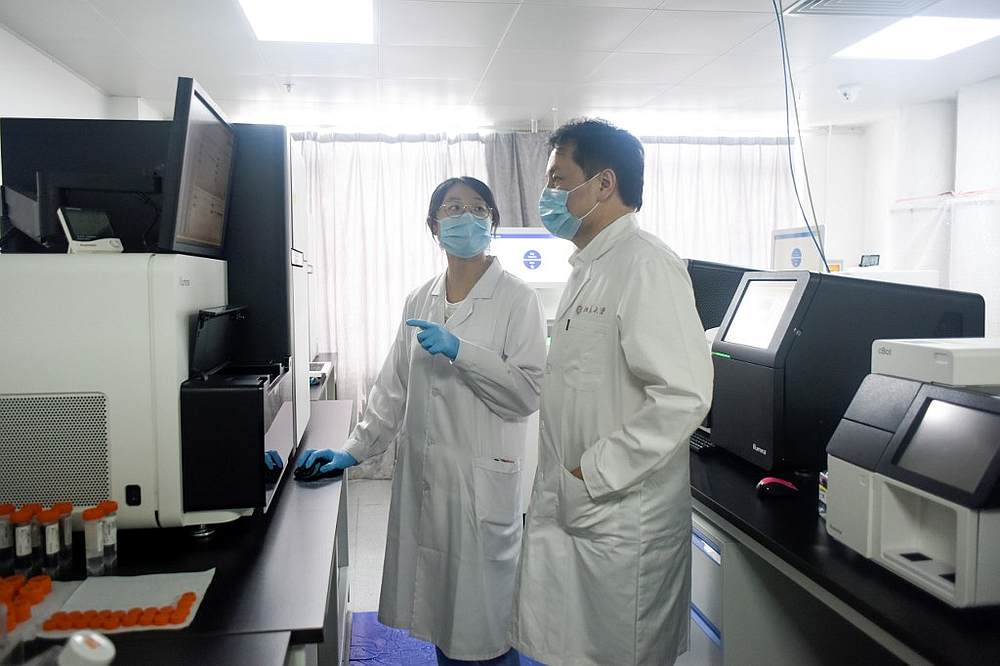 Sunney Xie (right), director of Peking University's Beijing Advanced Innovation Centre for Genomics, with a member of his research team at their laboratory in Beijing May 14, 2020. u00e2u20acu201d AFP pic