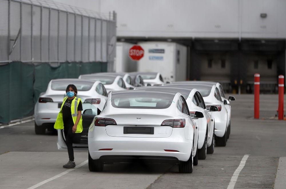 A worker exits a Tesla Model 3 electric vehicle at Teslau00e2u20acu2122s primary vehicle factory after CEO Elon Musk announced he was defying local officialsu00e2u20acu2122 coronavirus disease restrictions by reopening the plant in Fremont, California, May 11, 2020. u00e2u20acu201d Reuters 