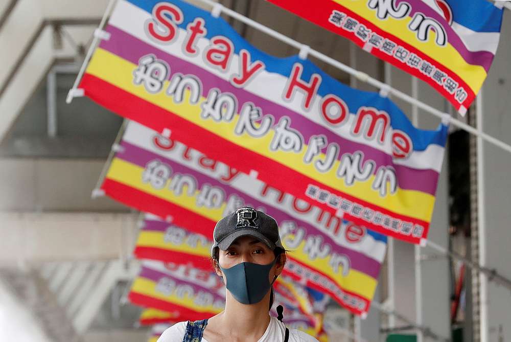 A woman wearing protective mask walks below banners reading 'Stay Home' at a local market district amid the Covid-19 outbreak in Tokyo, Japan May 13, 2020. u00e2u20acu201d Reuters pic