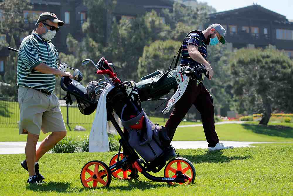 Golfers wear masks as they walk up the fairway at Torrey Pines golf course in San Diego, California May 4, 2020. u00e2u20acu201d Reuters pic