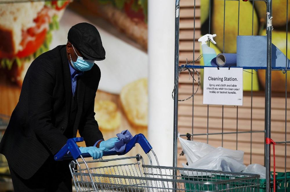 A man wearing a protective mask and gloves cleans a shopping trolley outside a Tesco supermarket in Kensington, as the spread of the coronavirus disease (Covid-19) continues, London, April 16, 2020. u00e2u20acu201d Reuters pic