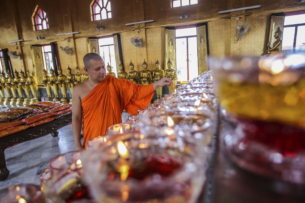 A monk lights oil lamps to mark Wesak Day at the Thai Buddhist Chetawan Temple in Petaling Jaya May 7, 2020. u00e2u20acu201d Picture by Hari Anggara