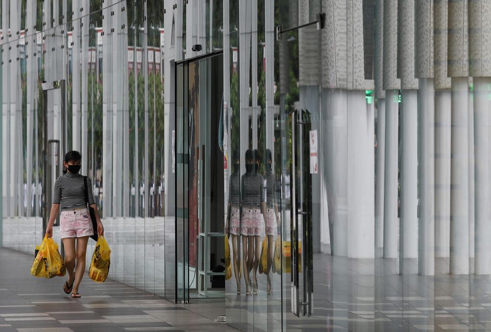 A woman wearing a protective face mask walks into a mall in Singapore. u00e2u20acu201d TODAY file pic