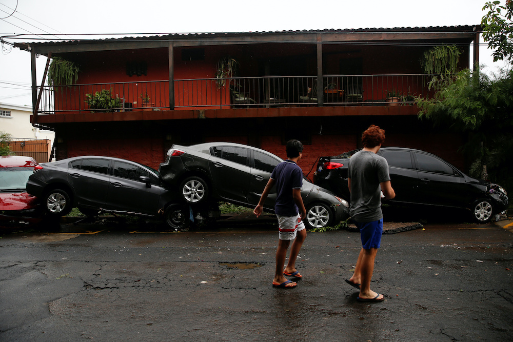 People walk in front of damaged cars during floods caused by Tropical Storm Amanda, in San Salvador, El Salvador May 31, 2020. u00e2u20acu201d Reuters pic