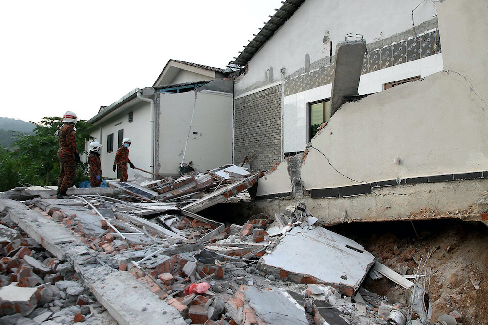 Members from a rescue squad and the Meru Raya fire and rescue station survey the area where an Indonesian worker was killed after a kitchen structure collapsed on him. u00e2u20acu201d Bernama pic
