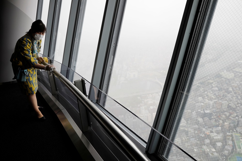 A staff member wearing a protective mask cleans a handrail with alcohol at an observation deck of Tokyo landmark u00e2u20acu02dcTokyo Skytreeu00e2u20acu2122, which reopened after a three-month closure in Tokyo June 1, 2020. u00e2u20acu201d Reuters pic