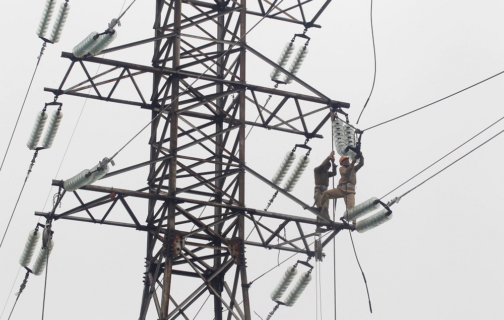Workers maintain an electric grid in Hanoi February 13, 2012. u00e2u20acu201d Reuters pic
