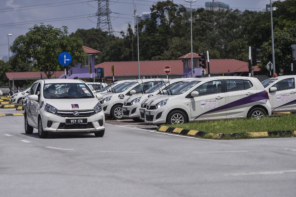 A driving school worker from Institut Memandu Kecemerlangan Latihan (IMKL) drives one of the training vehicles to ensure that the vehicle is in good condition for use on first day of operations in Setapak June 1, 2020. u00e2u20acu201d Picture by Miera Zulyana