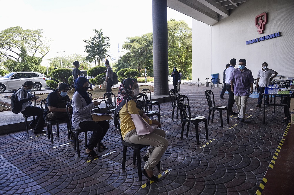 Customers practise social distancing as they wait in queue to pay their bills at the Kedai Tenaga branch in Shah Alam June 2, 2020. u00e2u20acu201d Picture by Miera Zulyana