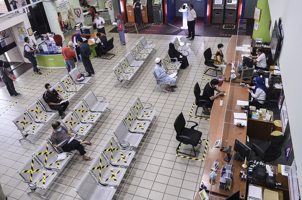 Customers practise social distancing as they wait in queue to pay their bills at the Kedai Tenaga branch in Shah Alam June 2, 2020. u00e2u20acu201d Picture by Miera Zulyana