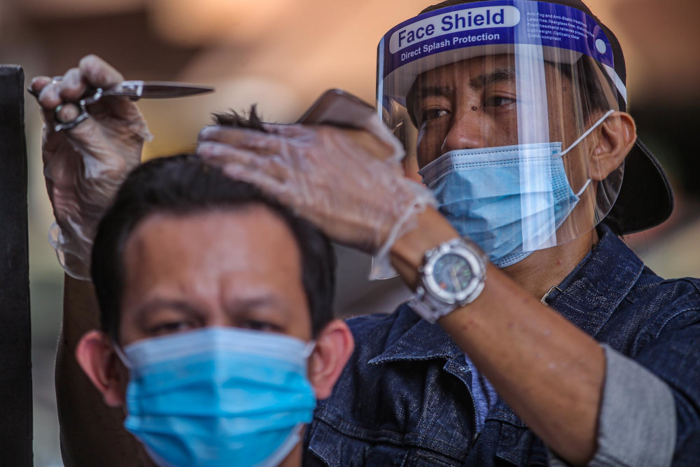 Genttouch Barbershop's Mohd Shahrin Saimin gives a demonstration of the standard operating procedures for barbers in Ampang June 7, 2020. — Picture by Hari Anggara