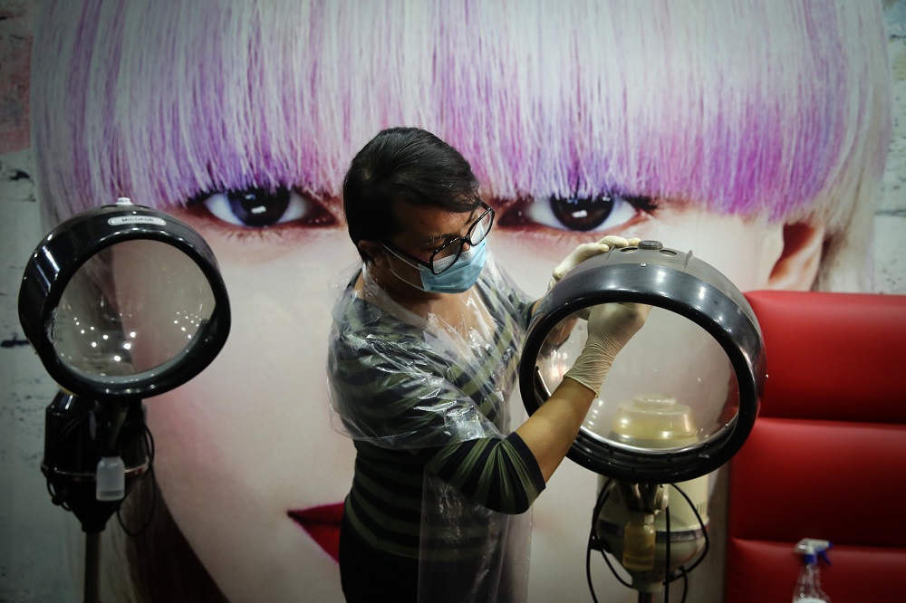 A worker disinfects equipment at a hair salon in Shah Alam June 8, 2020. u00e2u20acu201d Picture by Yusof Mat Isa