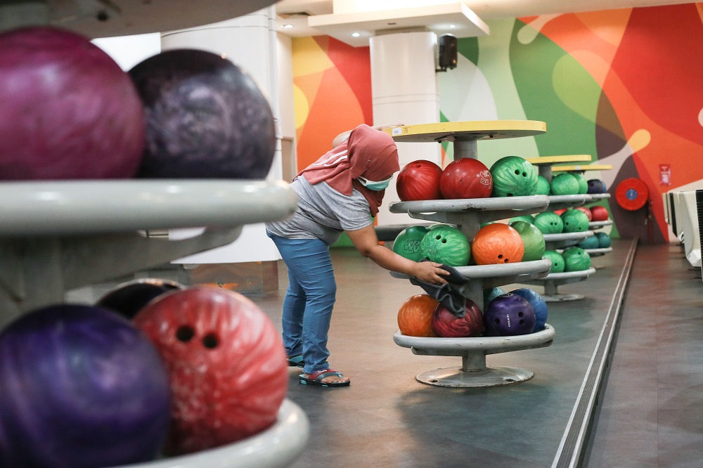 An employee disinfects bowling balls at Wangsa Bowl, a bowling centre located at Wangsa Walk Mall, in Kuala Lumpur June 9, 2020. u00e2u20acu201d Picture by Ahmad Zamzahuri