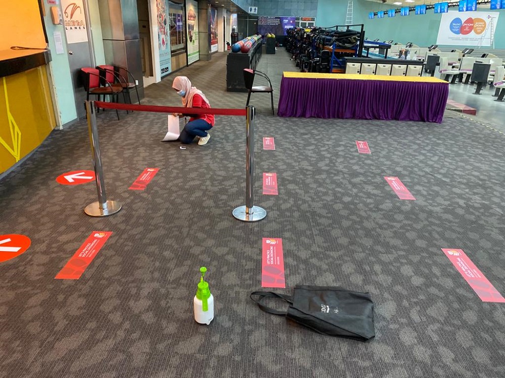 An employee puts up signs to guide customers on social distancing at Sunway Mega Lanes in preparation for reopening of the bowling centre in Subang Jaya. — Picture courtesy of Sunway Mega Lanes