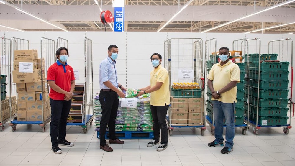 Tesco staff hand over the donated food items to Food Aid representatives. u00e2u20acu201d Picture courtesy of Tesco Malaysia. 