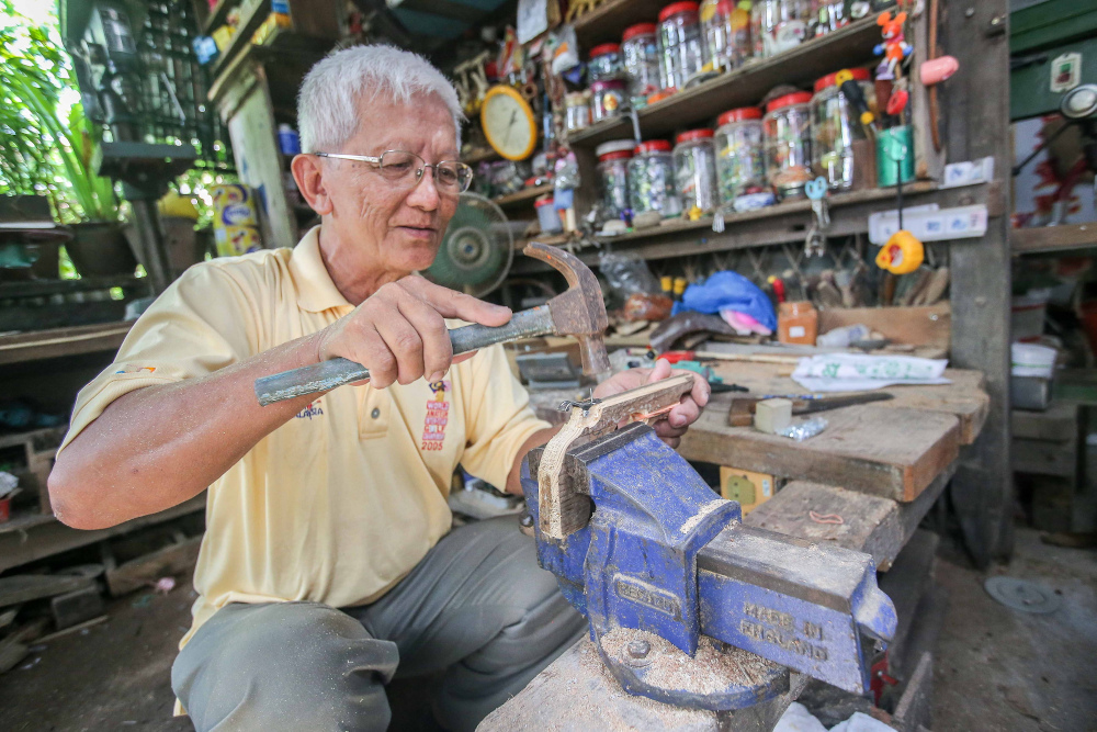 Retired headmaster Wee Ong Chin’s home at Sitiawan doubles up as his workshop where he prepares toys and souvenirs to be given out when he performs at charity events. — Picture by Farhan Najib 