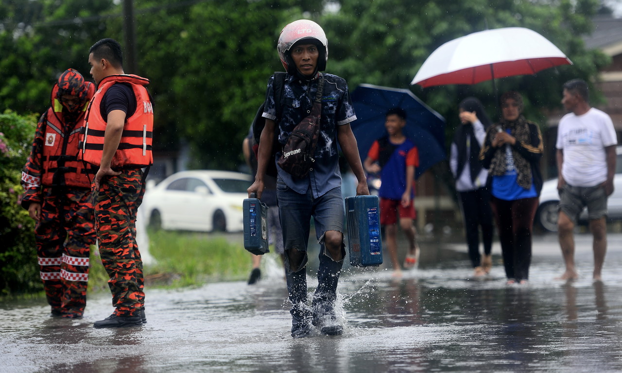 Kelihatan orang ramai di Kampung Parit Pasir Baru di kawasan Pekan Nenas Pontian meredah banjir kilat di Kampung Parit Pasir Baru pada tengahari 20 Jun, 2020. u00e2u20acu201d Foto Bernamann
