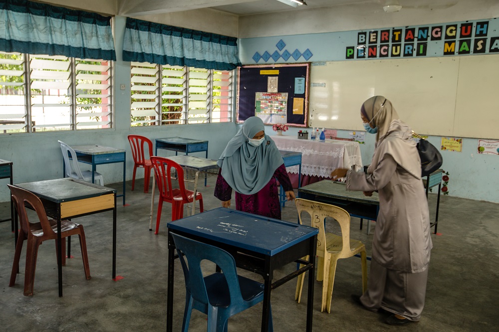 Teachers are seen arranging tables at a classroom in accordance to social distancing rules at the Sekolah Menengah Kebangsaan (SMK) Seksyen 19 in Shah Alam June 23, 2020. u00e2u20acu201d Picture by Firdaus Latif