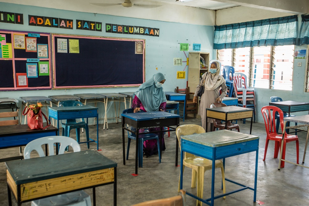 Teachers are seen arranging tables at a classroom in accordance to social distancing rules at the Sekolah Menengah Kebangsaan (SMK) Seksyen 19 in Shah Alam June 23, 2020. u00e2u20acu201d Picture by Firdaus Latif