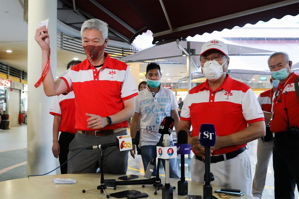 Dr Tan Cheng Bock (front row, right) presented a party membership card to Mr Lee Hsien Yang (front row, left) during a Progress Singapore Party breakfast meeting at Tiong Bahru Market on June 24, 2020. u00e2u20acu201d TODAY pic
