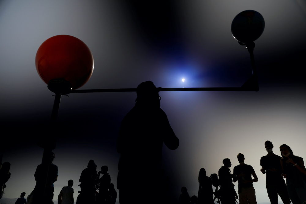 People stand next to a model of the earth, the moon and the sun as a partial solar eclipse is seen from Mount Scopus in Jerusalem June 21, 2020. u00e2u20acu201d Reuters pic