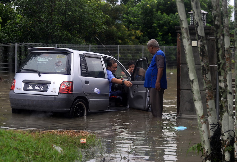 Sebuah kenderaan tersangkut di dalam banjir kilat di Kampung Parit Pasir Baru di kawasan Pekan Nenas Pontian semalam. u00e2u20acu201d Foto Bernama