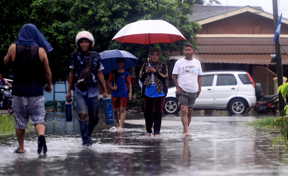 Residents of Kampung Parit Pasir Baru in the Pekan Nenas Pontian area wade through flood waters, June 20, 2020. u00e2u20acu201d Bernama pic