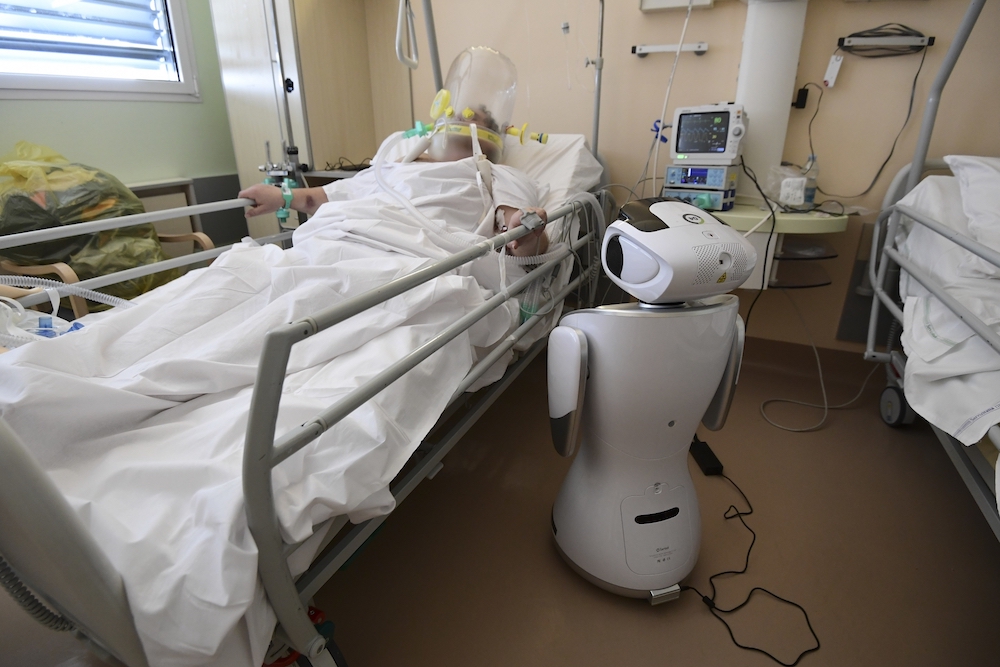 One of the six robots of the Circolo di Varese hospital in Italy stands near a patient, to help the healthcare staff of the High Intensity Medicine department. u00e2u20acu201d AFP pic