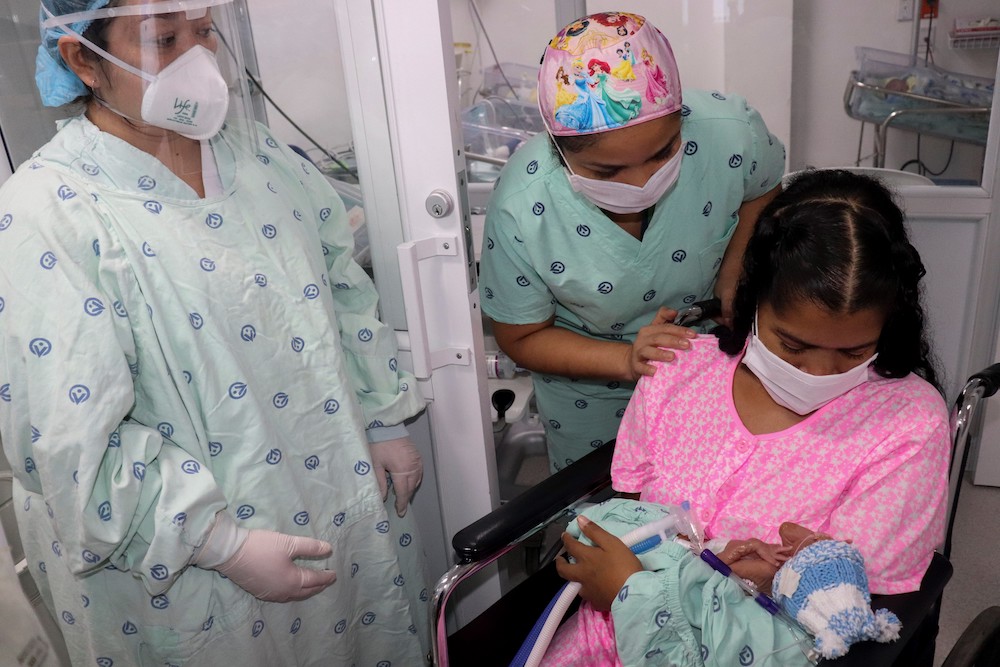 Handout picture released by the Clinica Versalles showing Diana Paola Angola holding her newborn baby for the first time, after she recovered from the Covid-19 coronavirus, at the Versalles Clinic, on June 23, 2020 in Cali, Colombia. u00e2u20acu201d AFP pic