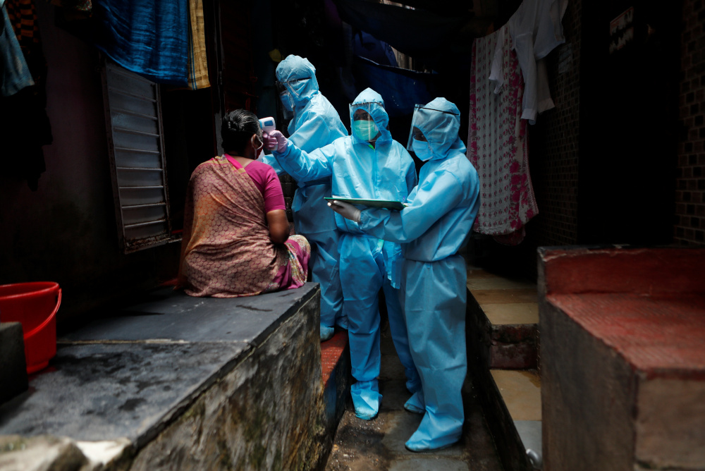 Healthcare workers check the temperature of a resident at a slum during a check-up camp for the coronavirus disease in Mumbai, India June 14, 2020. u00e2u20acu201d Reuters pic 