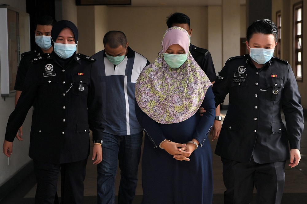 Mimi Khairani Baharudin (second right) and her husband Mohd Shaufik Ariffin (third left) are led to the Sessions Court in Kuala Lumpur June 18, 2020. u00e2u20acu201d Bernama pic