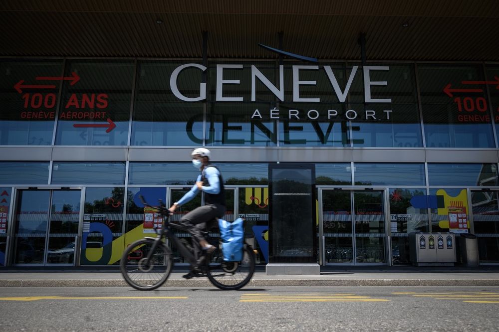 A man wearing a protective face mask rides his bicycle past the entrance of Geneva Airport amid the Covid-19 outbreak, caused by the novel coronavirus, on May 28, 2020, in Geneva, Switzerland. u00e2u20acu201d AFP pic