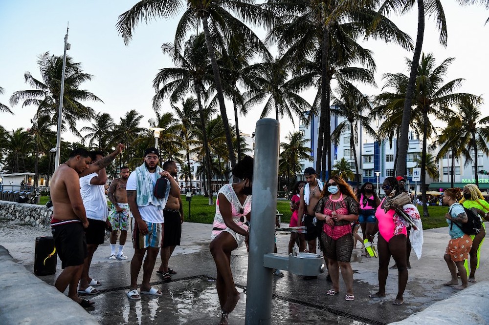 A woman rinse her feet as other wait in Miami Beach, Florida on June 26, 2020. — AFP pic