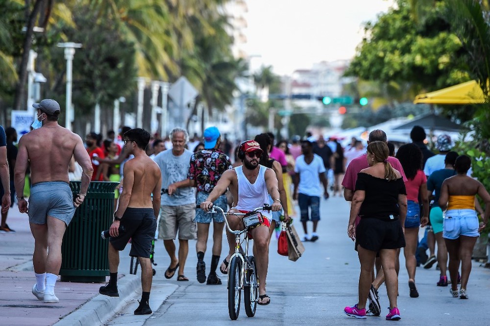 A man rides a bicycle as people walk on Ocean Drive in Miami Beach, Florida on June 26, 2020. u00e2u20acu201d AFP pic