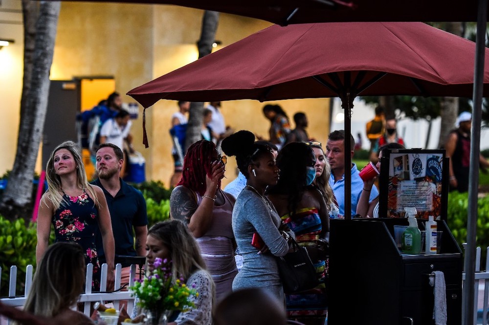 People stand in queue to enter a restaurant on Ocean Drive in Miami Beach, Florida on June 26, 2020. — AFP pic