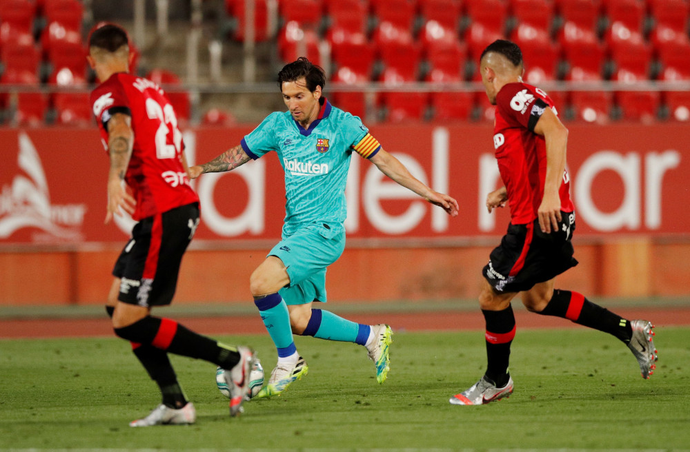 Barcelonau00e2u20acu2122s Lionel Messi in action with Mallorcau00e2u20acu2122s Ante Budimir, as play resumes behind closed doors following the outbreak of the coronavirus disease at the Iberostar Stadium in Spain June 13, 2020. u00e2u20acu201d Reuters pic