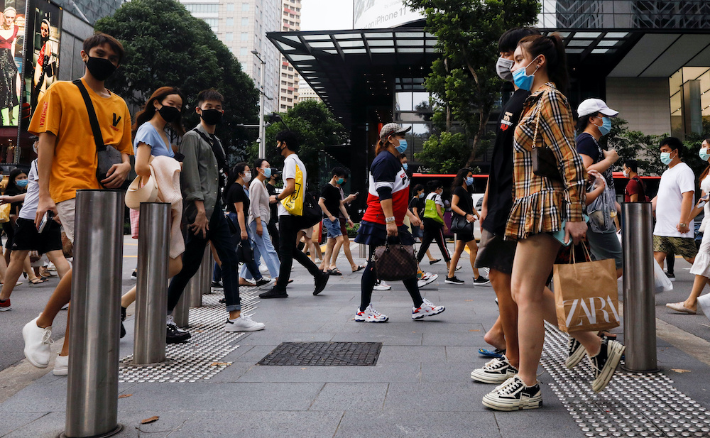 People cross a street at the shopping district of Orchard Road as the city state reopens the economy, amid the coronavirus disease outbreak, in Singapore June 19, 2020. u00e2u20acu2022 Reuters picnn