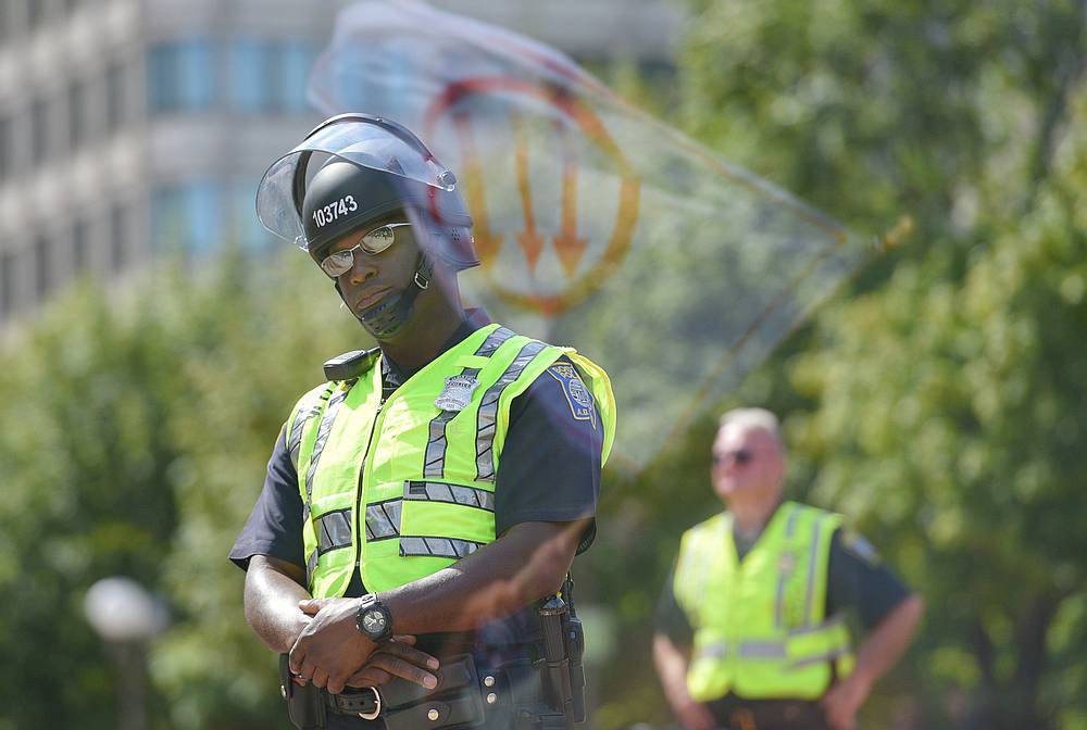 A flag, bearing a leftist symbol associated with Antifa, is reflected behind a Boston Police officer during the Straight Pride Parade rally in Boston, Massachusetts August 31, 2019. u00e2u20acu201d Reuters pic