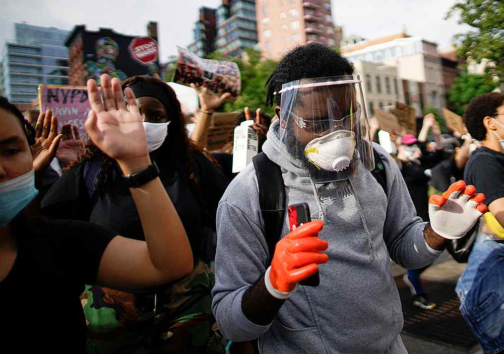 A protester wearing a face shield and mask raises his hands during a protest after the death in Minneapolis police custody of George Floyd, in New York June 11, 2020. u00e2u20acu201d Reuters pic 