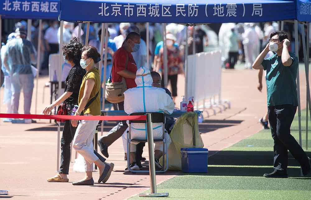 A medical worker in a protective suit conducts nucleic acid tests on residents at a sports stadium in Beijing, China June 14, 2020. u00e2u20acu201d cnsphoto via Reuters