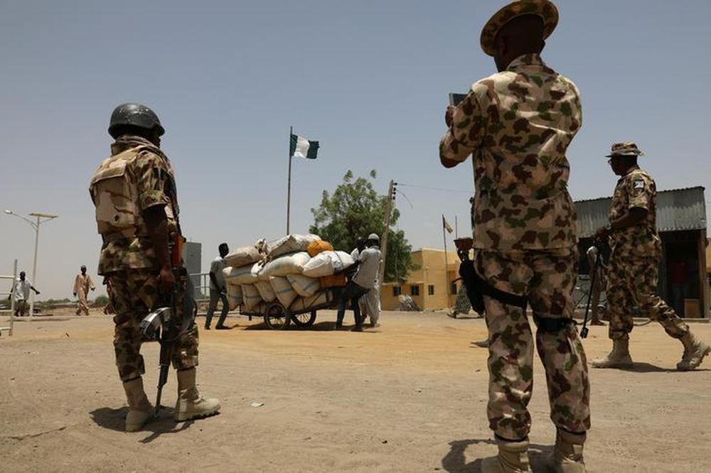 File picture shows men pushing a cart loaded with goods past soldiers at the border in Gamboru Ngala, Borno, Nigeria April 27, 2017. u00e2u20acu201d Reuters pic