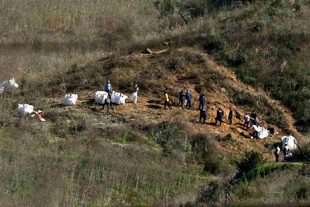 Personnel collect debris while working with investigators at the helicopter crash site of NBA star Kobe Bryant in Calabasas, California January 28, 2020. u00e2u20acu201d Reuters pic