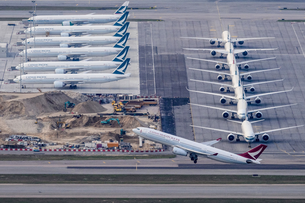 In this file photo taken March 10, 2020, a Cathay Dragon passenger airplane takes off as Cathay Pacific aircraft are seen parked on the tarmac at Hong Kongu00e2u20acu2122s Chek Lap Kok International Airport. u00e2u20acu201d AFP pic  
