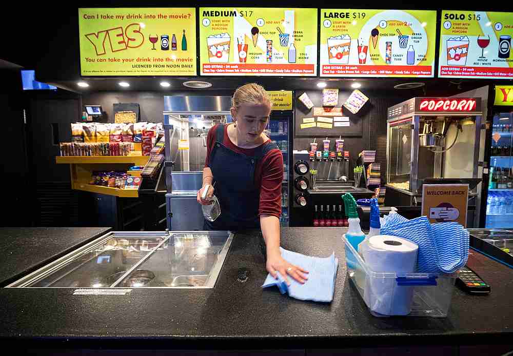 A worker disinfects high-touch areas for the reopening of a cinema following the easing of Covid-19 restrictions in Melbourne, Australia June 22, 2020. u00e2u20acu201d AAP Image via Reuters