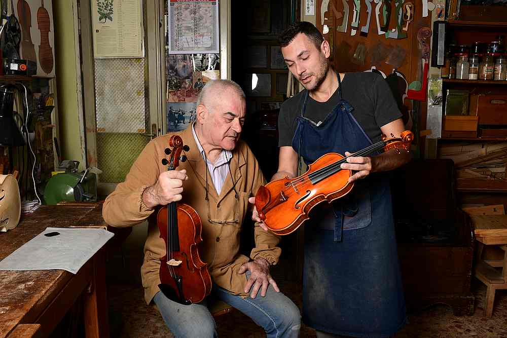 Cremona's current oldest luthier, Hungary's Stefano Conia (74), and his son Stefano Jr (47) are seen with a violin at their workshop in Cremona June 9, 2020. u00e2u20acu201d AFP pic