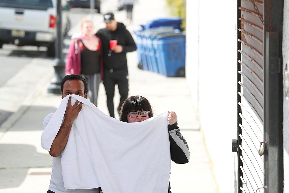A couple uses a towel to cover their faces as they walk past businesses closed due to the ongoing national outbreak of Covid-19 in Atlantic City, New Jersey May 19, 2020. u00e2u20acu201d Reuters pic