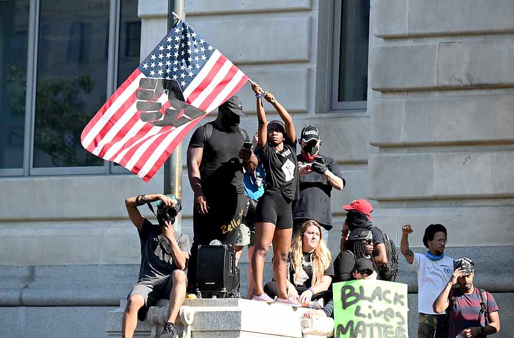 Philomena Wankenge of Freedom Fighters DC waves a flag as demonstrators gather in front of the John A. Wilson District Building in Washington June 6, 2020. u00e2u20acu201d Reuters pic